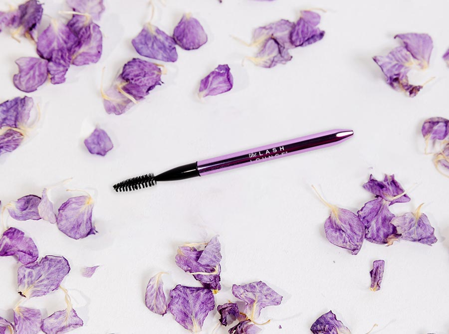 The Lash Lounge's Metal Mascara Brush laying down on a marble counter.