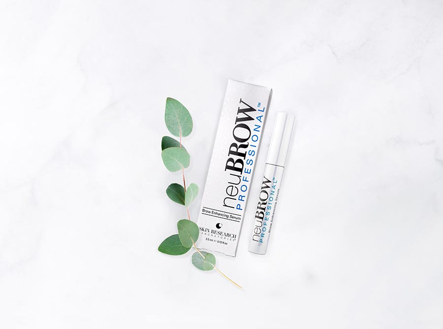 neuBROW PROFESSIONAL™ brow enhancing serum laying down on a marble counter.