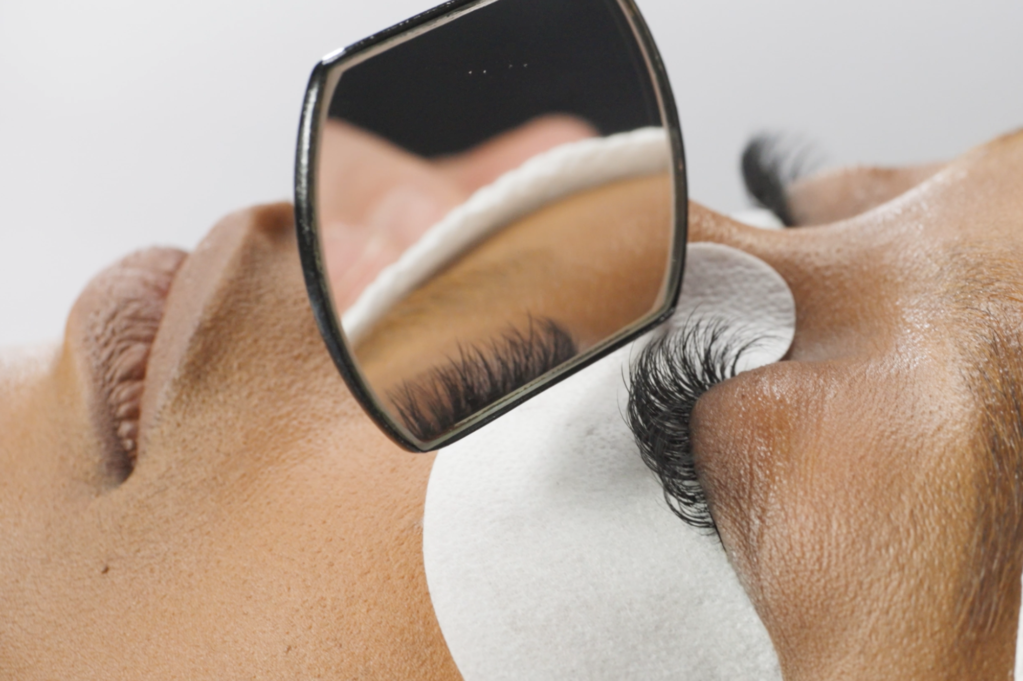 side view of dental mirror looking at a woman's full set of custom lashes