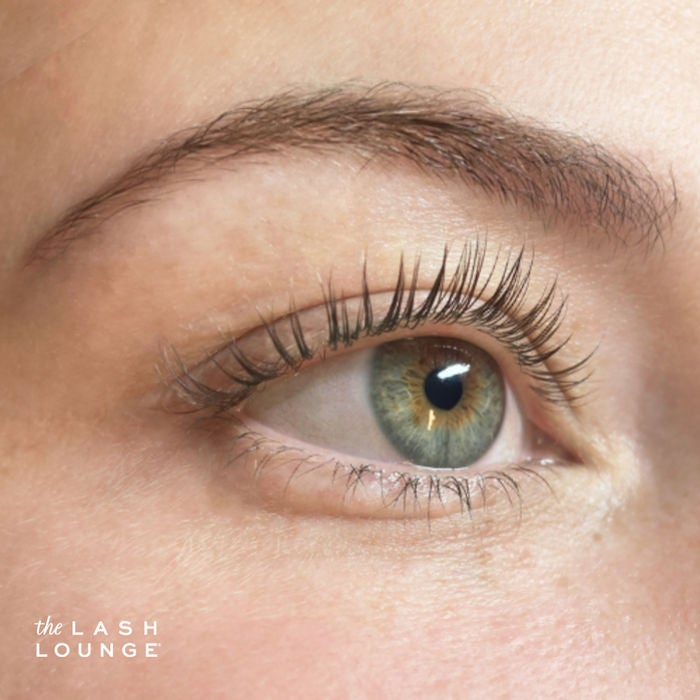 Close-up of woman's green eye with a lash and brow tint