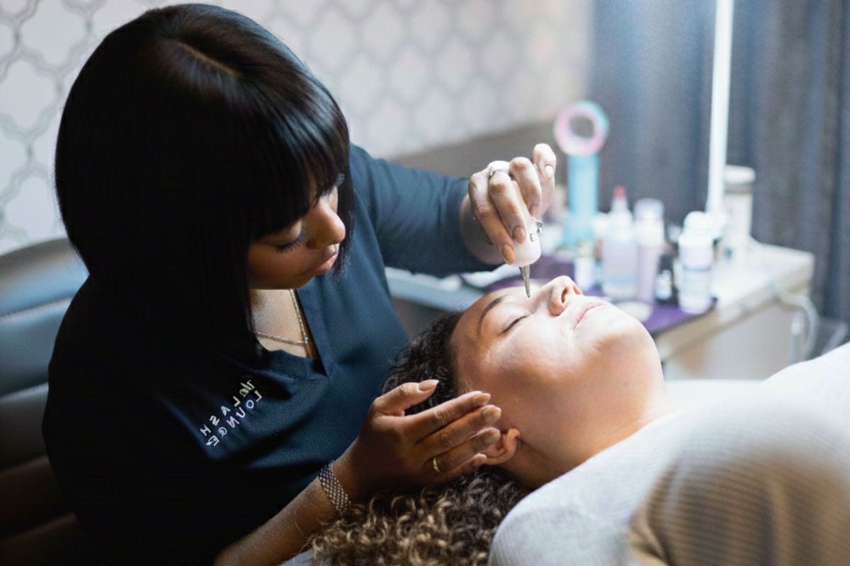 Lash stylist and guest during a service