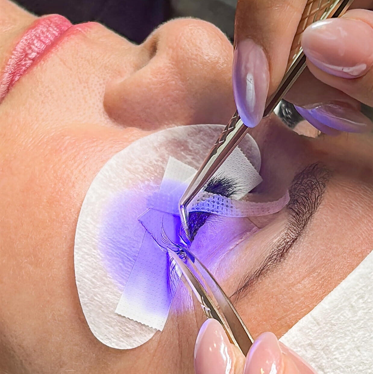 purple light experience in action, lashes being applied by a lash lounge stylist