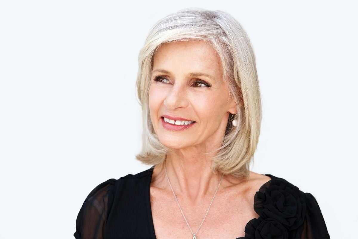 Mature adult woman with grey hair and thinning eyebrows.